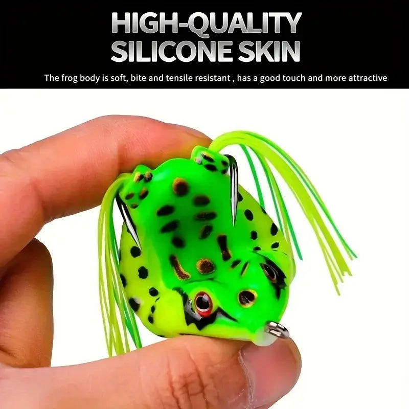 Hand holding a green frog soft lure with realistic features and silicone skin, perfect for fishing.