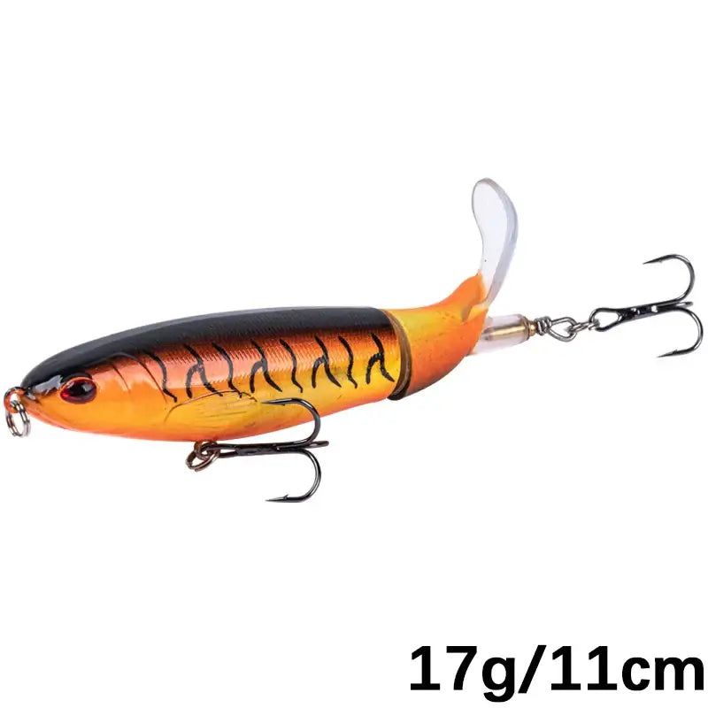 Goture Whopper Popper 11cm topwater fishing lure in orange and black with rotating tail for pike and predator fishing.