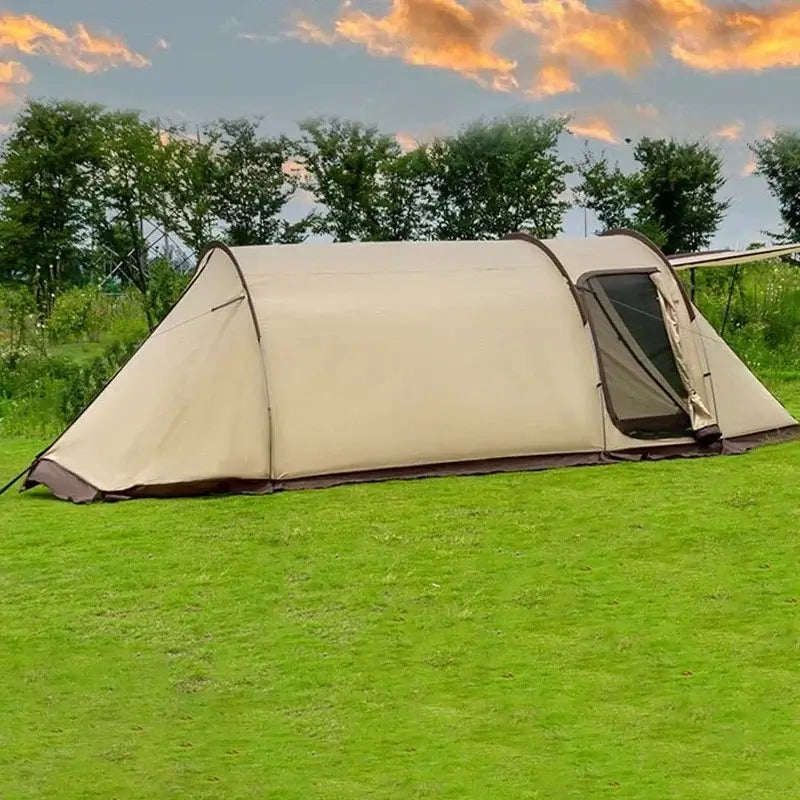 Beige outdoor camping tent with one bedroom and living space set on grass, designed for windproof and rainproof shelter.