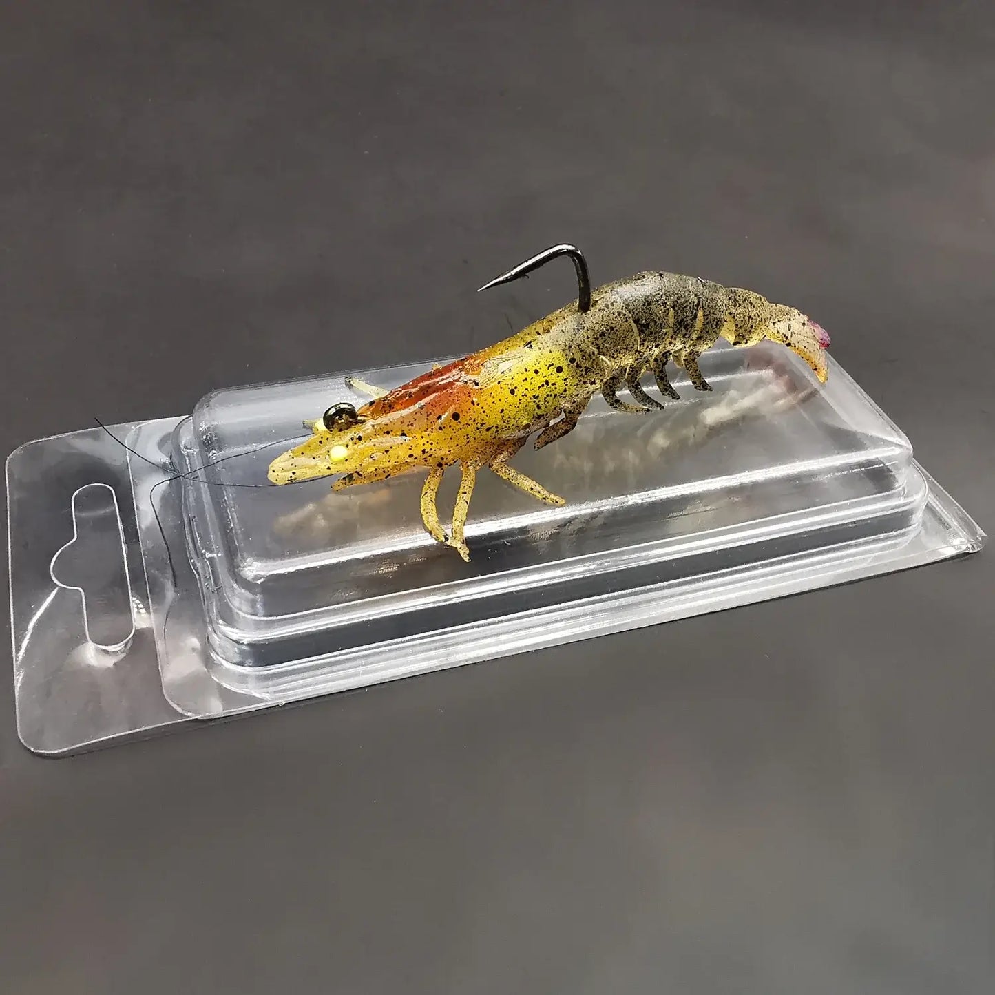 Luminous soft bait prawn fishing lure on packaging for bass, trout, walleye fishing in freshwater and saltwater.