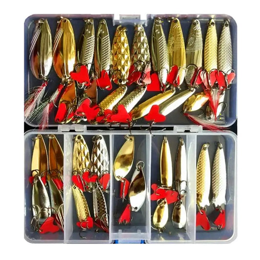 Set of gold metal jig spoons with red accents in a tackle box, ideal for various fishing environments.